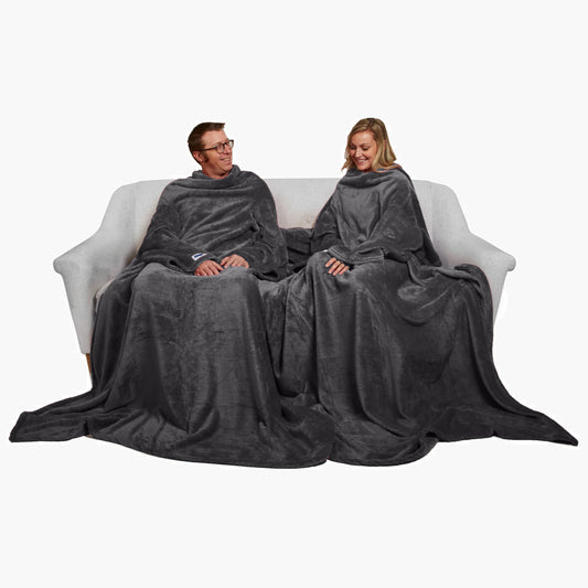 Slanket Siamese - The Original Blanket with Sleeves shown being used by a couple on a couch