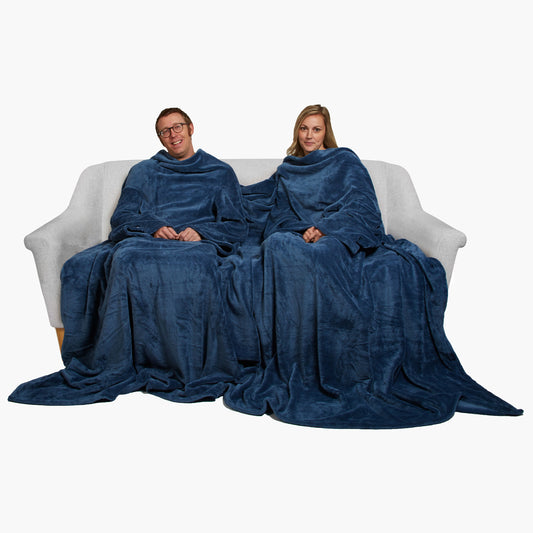 Slanket Siamese - The Original Blanket with Sleeves shown being used by a couple on a couch
