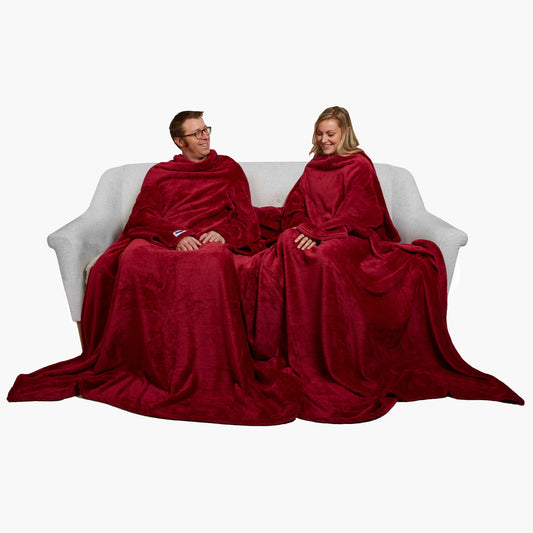 Slanket Siamese - The Original Blanket with Sleeves shown being used by a couple on a couch