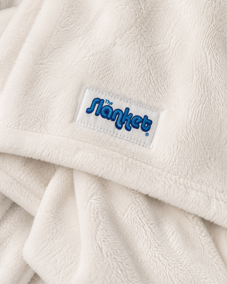 Close-up of soft white fleece with the blue Slanket logo tag