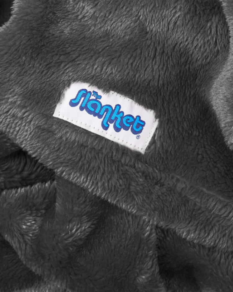 Close-up of gray fleece with the blue Slanket logo tag
