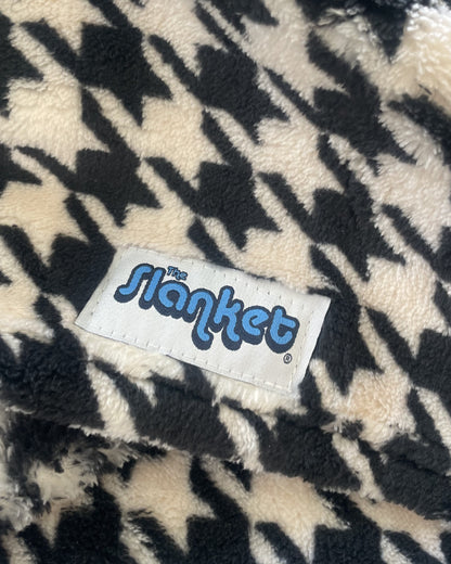 Close-up of black and white houndstooth fleece with the blue Slanket logo tag