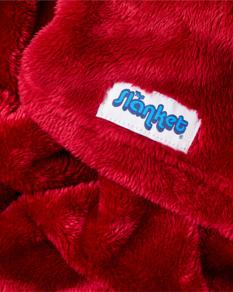 Close-up of deep ruby red fleece with the blue Slanket logo tag