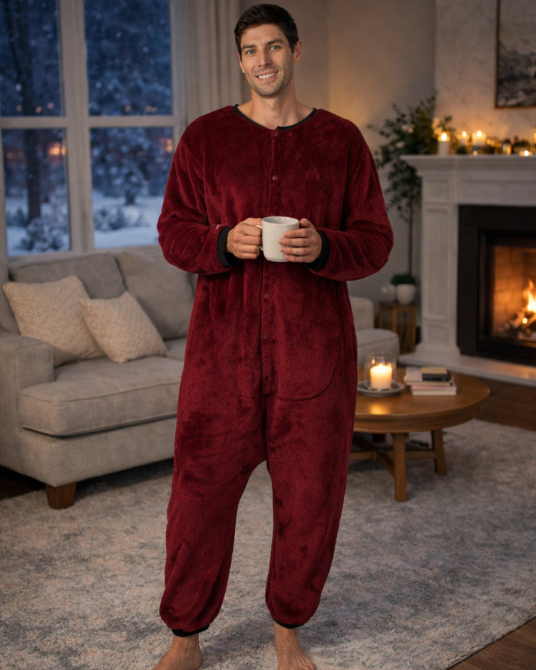 Person in an adult onesie standing in the living room with a cup of coffee