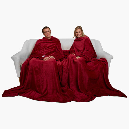 Slanket Siamese - The Original Blanket with Sleeves shown being used by a couple on a couch