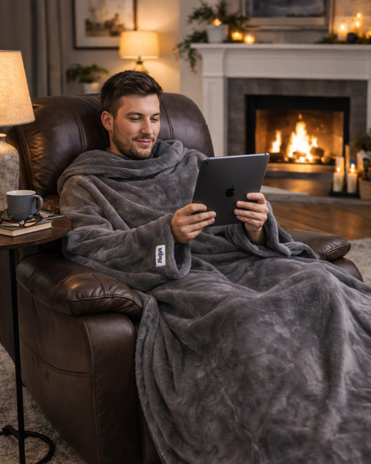 Man reading a tablet by the fireplace in a Gray Slanket
