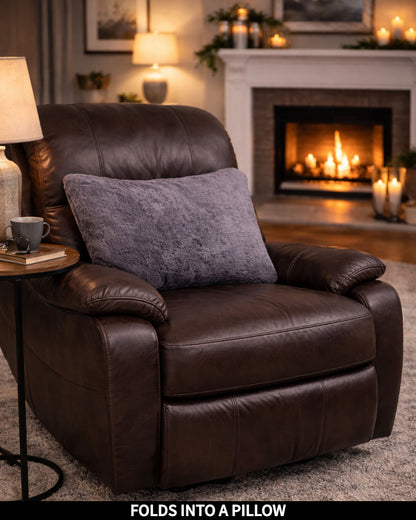 Gray Slanket folded into a pillow on a recliner, captioned Folds Into a Pillow