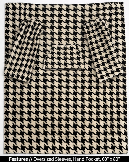 Houndstooth Slanket laid flat, front view, with callouts for oversized sleeves and hand pocket, 60 x 80 in