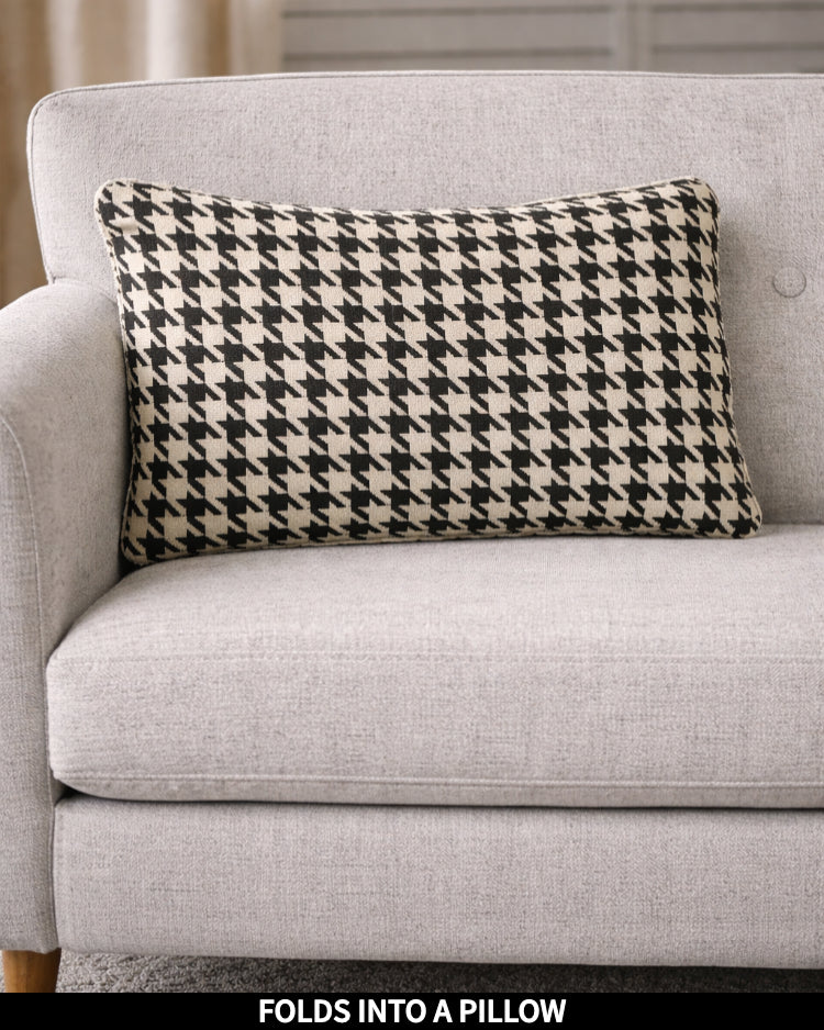 Houndstooth Slanket folded into a pillow, shown as a decorative cushion, captioned Folds Into a Pillow