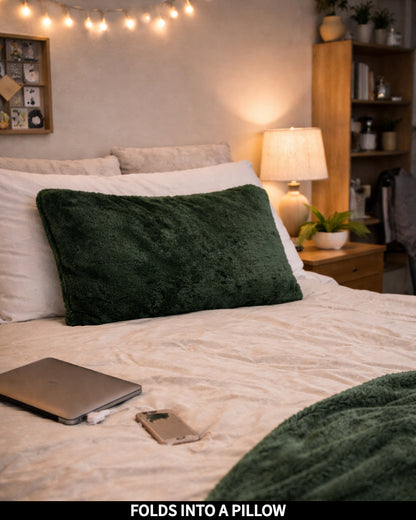 Hunter Green Slanket folded into a pillow on a bed, captioned Folds Into a Pillow