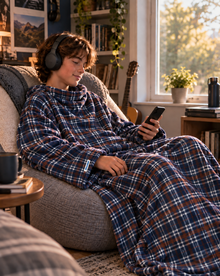 Boy wearing headphones and holding a phone in a Nor'easter Plaid Slanket Jr.