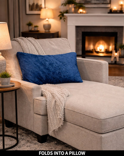Limoges Slanket folded into a pillow on a chaise, captioned Folds Into a Pillow