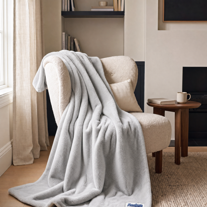 Slanket Rogue plush throw in Ghost light gray draped over an armchair