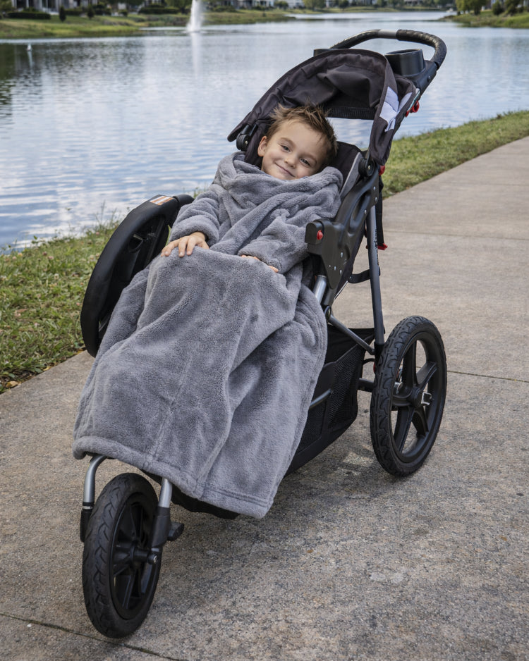 Product image of a little boy using Stroller Slanket while sitting in her stoller