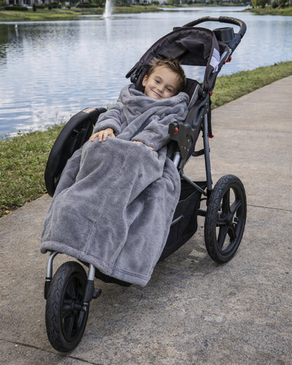 Product image of a little boy using Stroller Slanket while sitting in her stoller