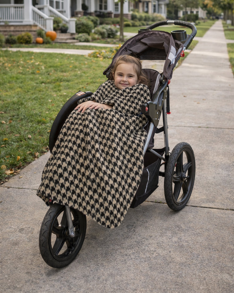 Product image of a little girl using Stroller Slanket while sitting in her stoller