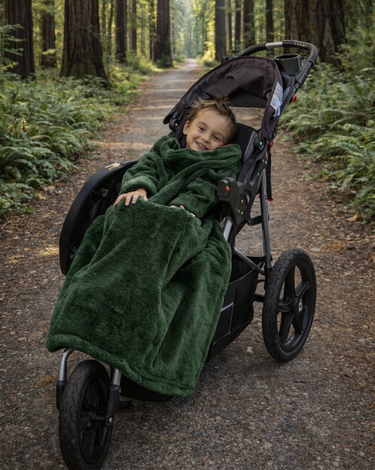 Product image of a little boy using Stroller Slanket while sitting in her stoller