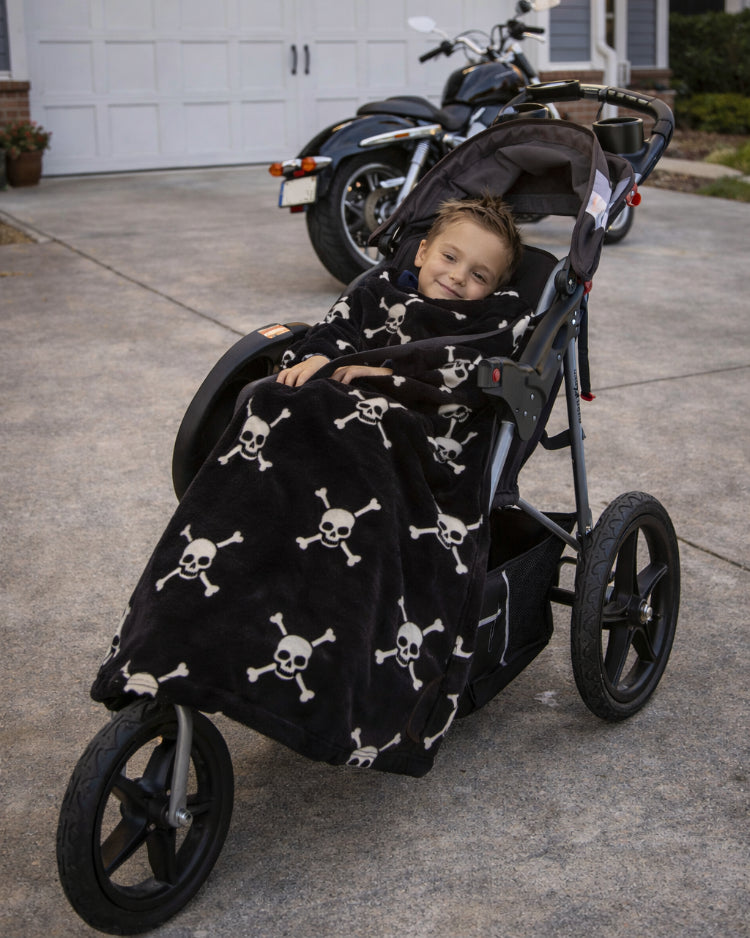 Product image of a little boy using Stroller Slanket while sitting in her stoller