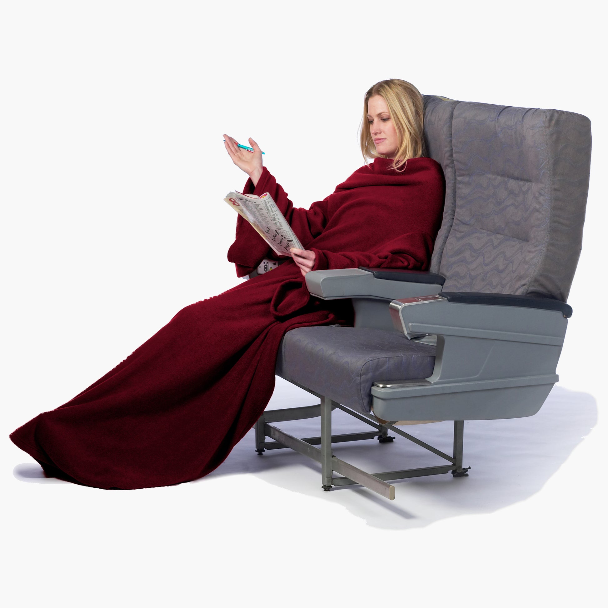 The Ultimate Slanket - The Original Blanket with Sleeves. Women using it while sitting in airplane seat doing a crosswords puzzle