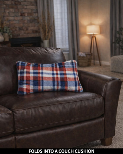 Slanket folds into a couch pillow then placed on a brown leather couch in a living room setting.